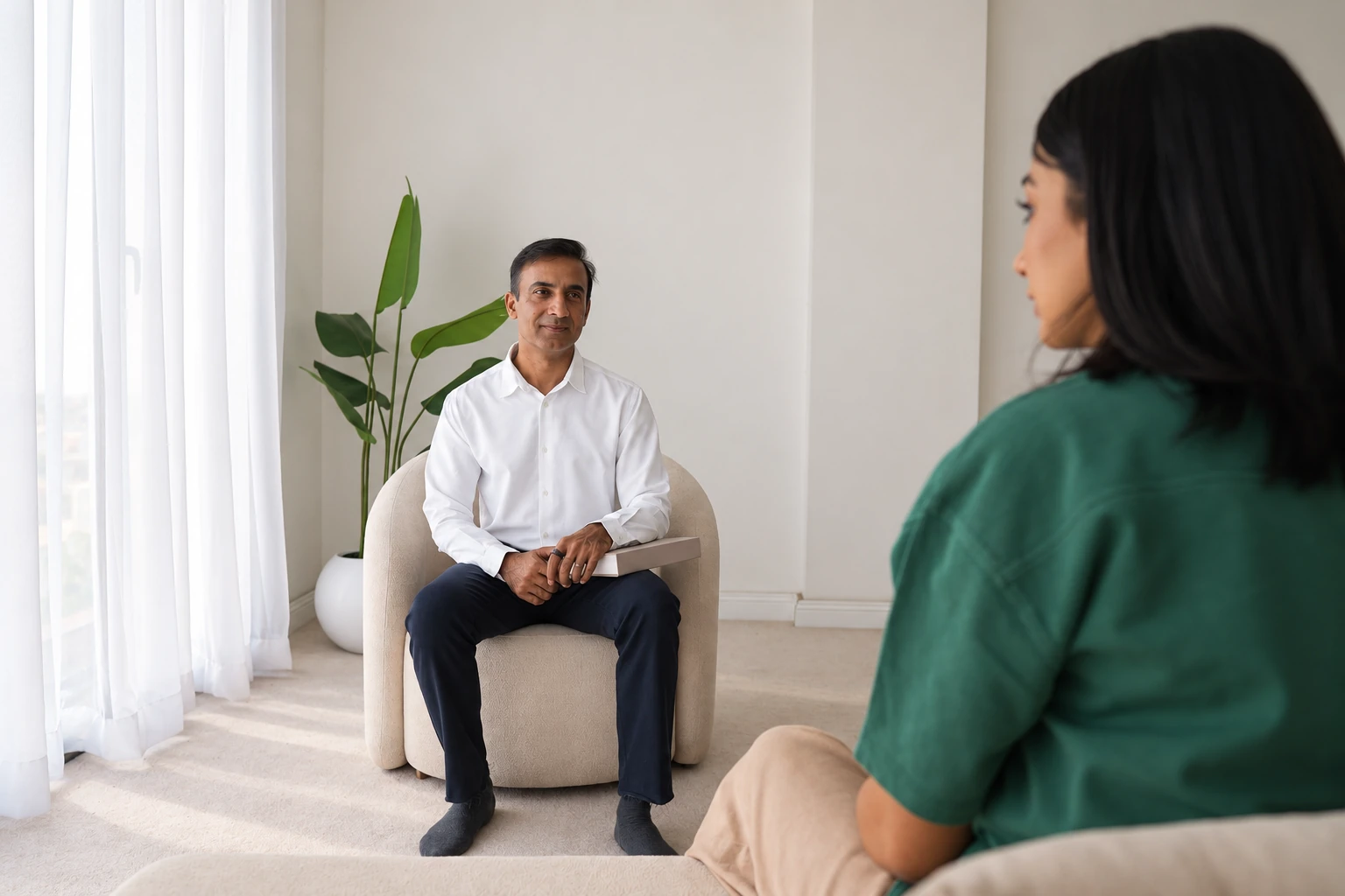Rai in conversation with a client in a calm, light-filled practice room